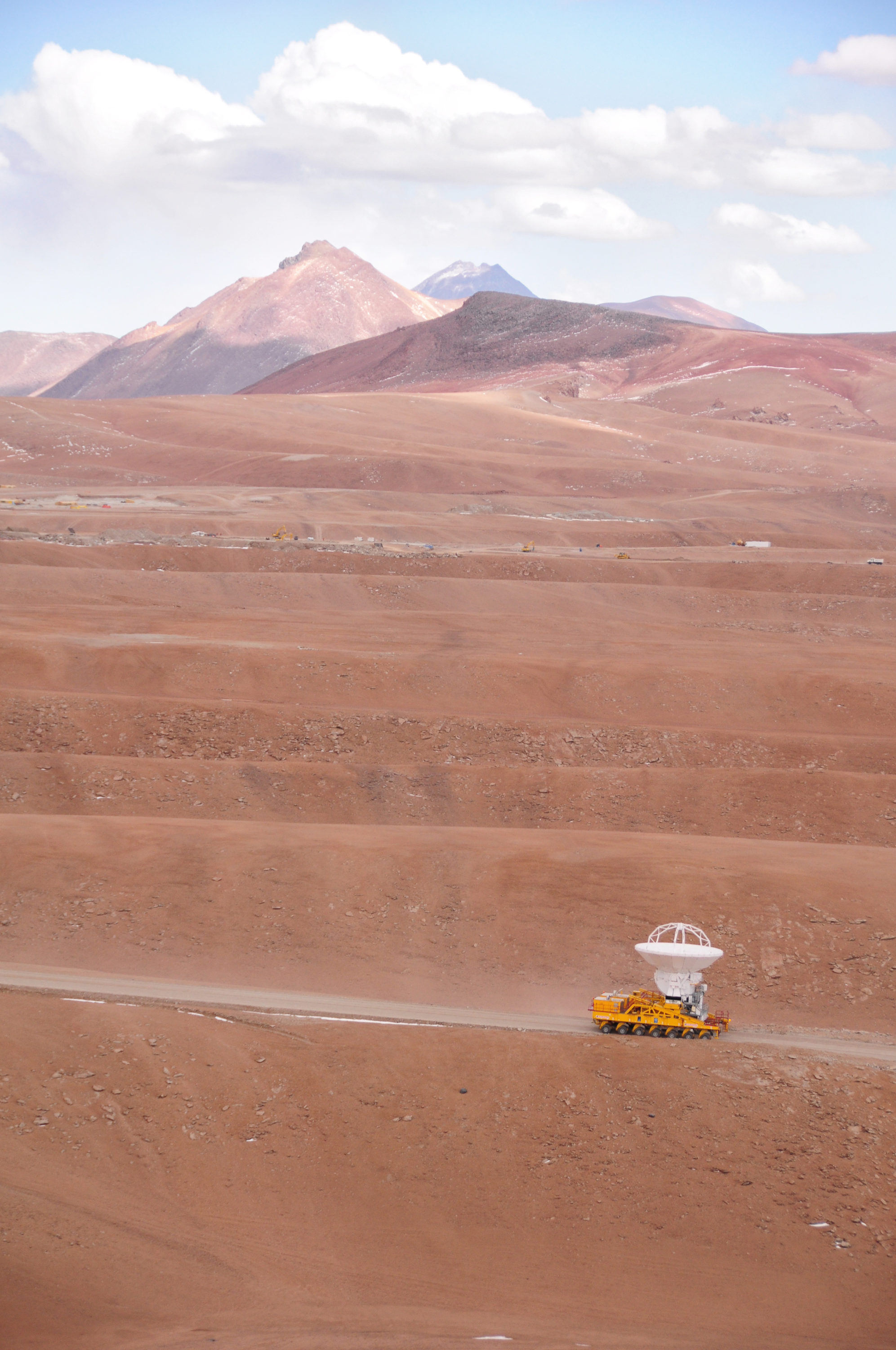 17 de septiembre de 2009: Una antena de ALMA en ruta desde la Instalación de Apoyo de Operaciones a la meseta de Chajnantor por primera vez. El vehículo transportador ALMA transporta cuidadosamente la antena de última generación, con un diámetro de 12 metros y un peso de aproximadamente 100 toneladas, en el viaje de 28 km hasta el sitio, que se encuentra a una altitud de 5000 m. La antena está diseñada para soportar las duras condiciones en el sitio alto, donde el aire extremadamente seco y enrarecido es ideal para las observaciones de ALMA del Universo en longitudes de onda milimétricas y submilimétricas. © Ralph Bennett - ALMA (ESO / NAOJ / NRAO)