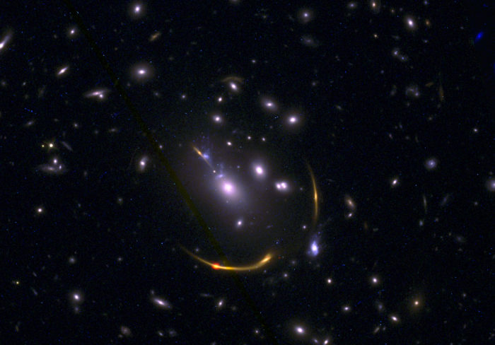 Imagen compuesta del cúmulo de galaxias MACSJ 0138 con datos del Atacama Large Millimeter/submillimeter Array (ALMA) y del telescopio espacial Hubble de la NASA obtenidos en el marco del estudio REQUIEM. Las imágenes de las galaxias masivas del Universo primitivo revelaron que estas carecen del gas de hidrógeno frío necesario para producir estrellas. Créditos: ALMA (ESO/NAOJ/NRAO)/S. Dagnello (NRAO), STScI, K. Whitaker et al.