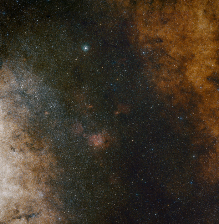 La vista del amplio campo de luz visible muestra ricas nubes de estrellas en la constelación de Sagitario (el Arquero) en la dirección del centro de nuestra galaxia, la Vía Láctea. La imagen completa está llena de un vasto número de estrellas, pero muchas más permanecen escondidas tras las nubes de polvo y sólo son reveladas en imágenes infrarrojas como la panorámica de VISTA. Esta visión fue creada a partir de fotografías en luz roja y azul, y forman parte del Digitized Sky Survey 2. El campo de visión es de aproximadamente 3,5 grados por 3,6 grados. Crédito: ESO and Digitized Sky Survey 2. Acknowledgment: Davide De Martin and S. Guisard (www.eso.org/~sguisard)