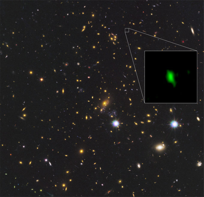 En esta imagen se aprecia el cúmulo de galaxias MACS J1149.5+2223 observado por el telescopio espacial Hubble de la NASA/ESA, y el recuadro muestra la galaxia MACS1149-JD1, observada por ALMA, a 13.280 millones de años luz de distancia. La distribución del oxígeno detectada por ALMA se muestra en verde. Créditos: ALMA (ESO/NAOJ/NRAO), telescopio espacial Hubble de la NASA/ESA, W. Zheng (JHU), M. Postman (STScI), CLASH Team, Hashimoto et al.