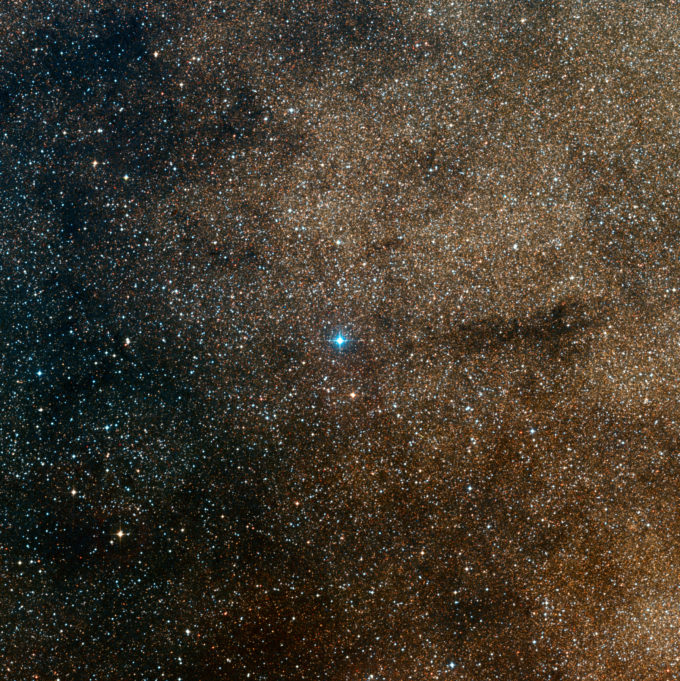 Esta imagen de amplio campo muestra los alrededores de la joven estrella HD 163296 en la rica constelación de Sagitario (el arquero). Esta fotografía fue creada a partir de imágenes que forman parte del sondeo Digitized Sky Survey 2. HD 163296 es la estrella azulada brillante del centro. Crédito: ESO/Digitized Sky Survey 2; Acknowledgement: Davide De Martin