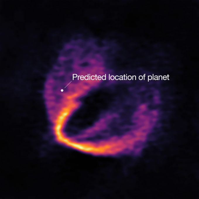 ALMA has uncovered convincing evidence that three young planets are in orbit around the infant star HD 163296. Using a novel planet-finding technique, astronomers have identified three discrete disturbances in the young star’s gas-filled disc: the strongest evidence yet that newly formed planets are in orbit there. These are considered the first planets discovered with ALMA.This image shows part of the ALMA data set at one wavelength and reveals a clear “kink” in the material, which indicates unambiguously the presence of one of the planets. The annotation shows the predicted position of the planet in question. Credit: ESO, ALMA (ESO/NAOJ/NRAO); Pinte et al.