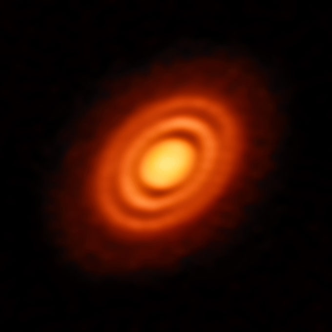 Nuestro Sistema Solar se formó a partir de una enorme nube primordial de gas y polvo. Gran parte de esa nube formó el Sol, mientras que el disco sobrante de material en rotación alrededor de él, se unió, formando finalmente los planetas que lo orbitan y que hoy conocemos (incluido el planeta en el que vivimos). Los astrónomos pueden observar procesos similares que tienen lugar alrededor de otras estrellas. Esta espléndida imagen de la semana muestra un disco en rotación de material sobrante alrededor de la joven estrella HD 163296. Usando las capacidades de observación de ALMA (Atacama Large Millimeter/submillimeter Array), en Chile, los astrónomos han podido discernir características específicas en el disco, incluyendo los anillos concéntricos de material que rodean a la estrella central. Gracias a ALMA, fueron incluso capaces de obtener medidas de alta resolución de los componentes de gas y polvo del disco. Con estos datos han podido inferir detalles clave de la historia de la formación de este joven sistema estelar. Las tres brechas que hay entre los anillos se deben, probablemente, a una disminución en la cantidad de polvo y, tanto en el hueco central como en el exterior, los astrónomos también encontraron niveles de gas inferiores. La menor cantidad de polvo y gas sugiere la presencia de planetas recién formados, cada uno de una masa similar a la de Saturno, esculpiendo estas brechas en sus nuevas órbitas. Crédito: ESO, ALMA (ESO/NAOJ/NRAO); A. Isella; B. Saxton (NRAO/AUI/NSF)
