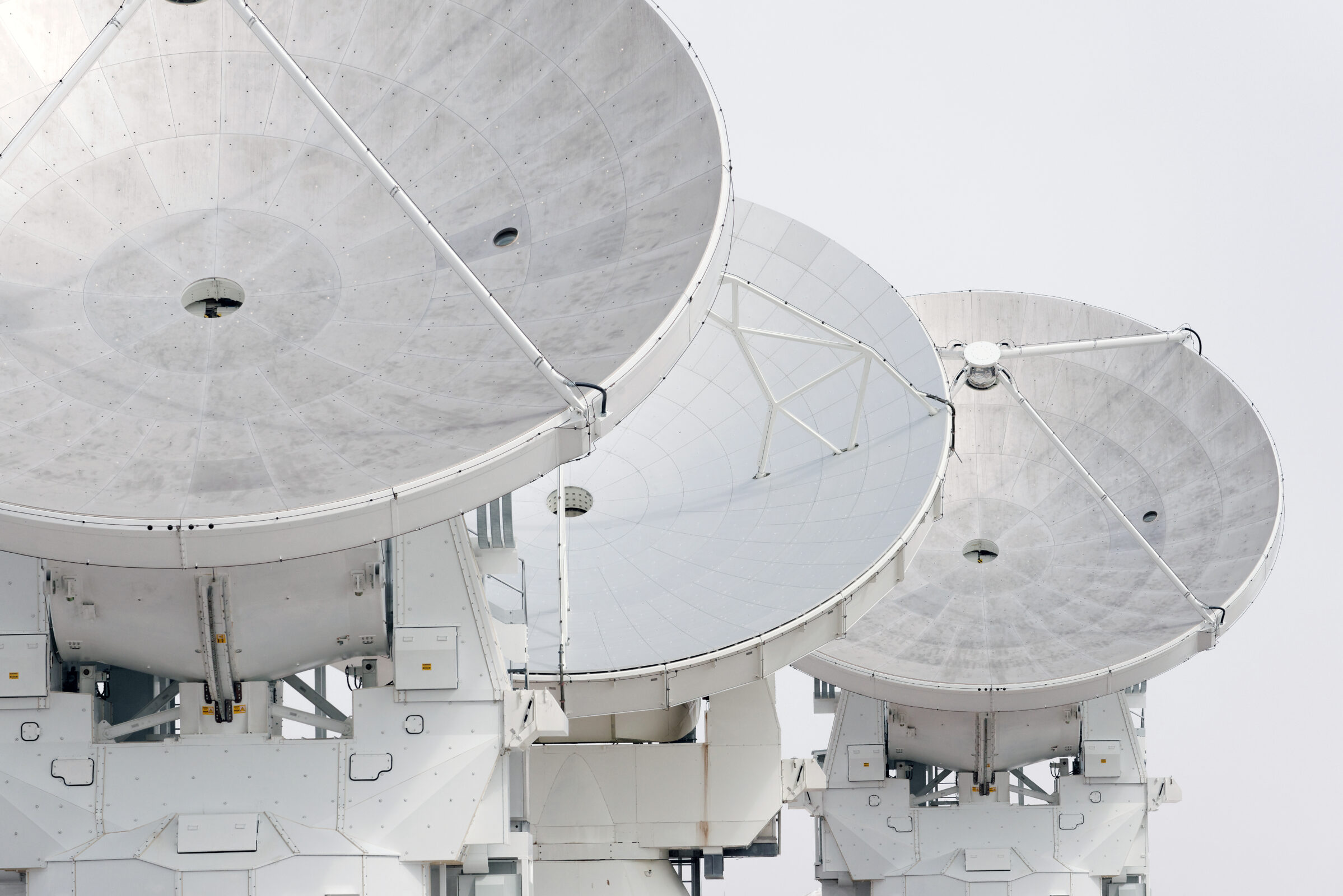 White ALMA antennas over white sky