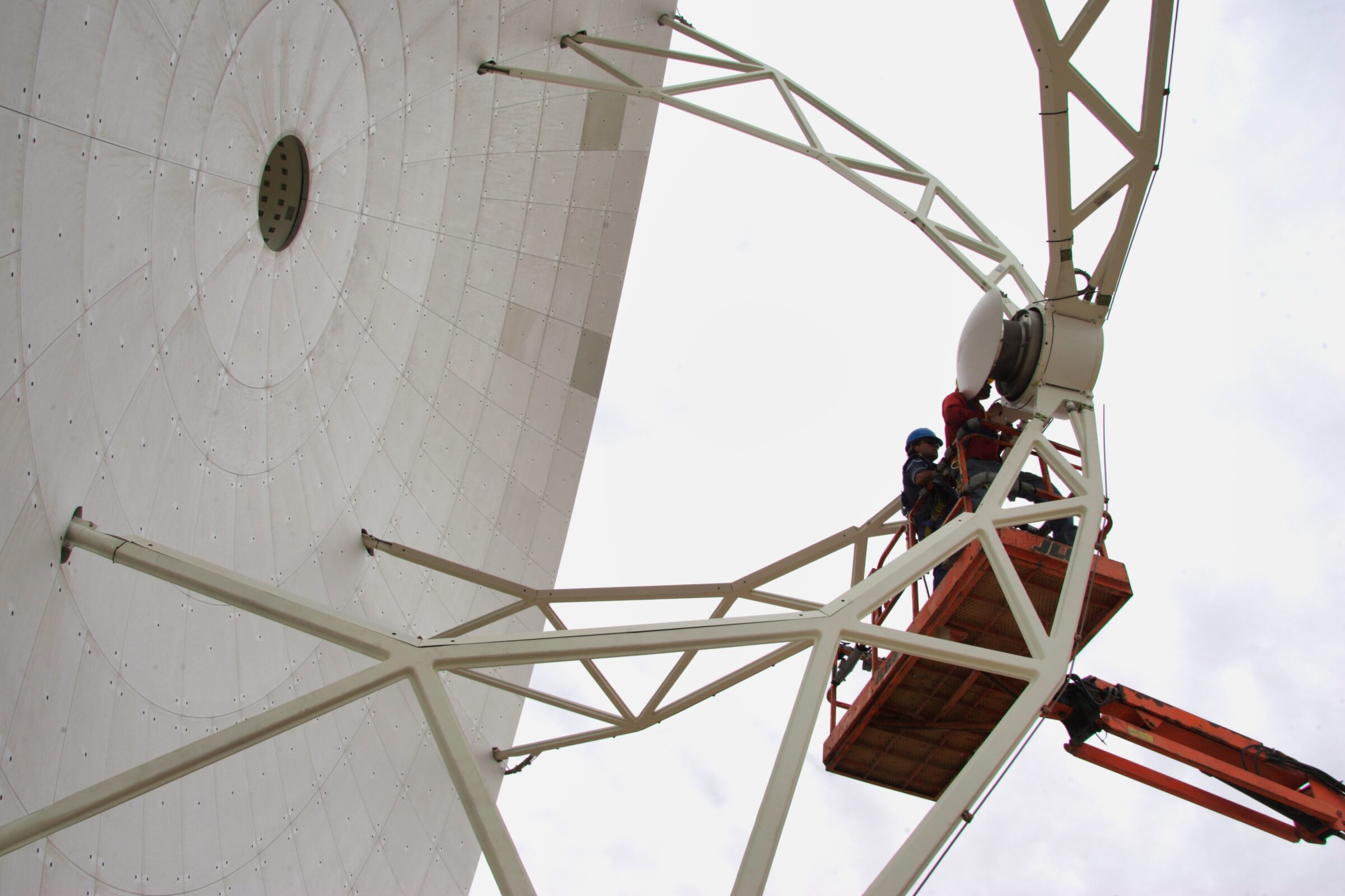 ALMA technicians in front of an antenna dish