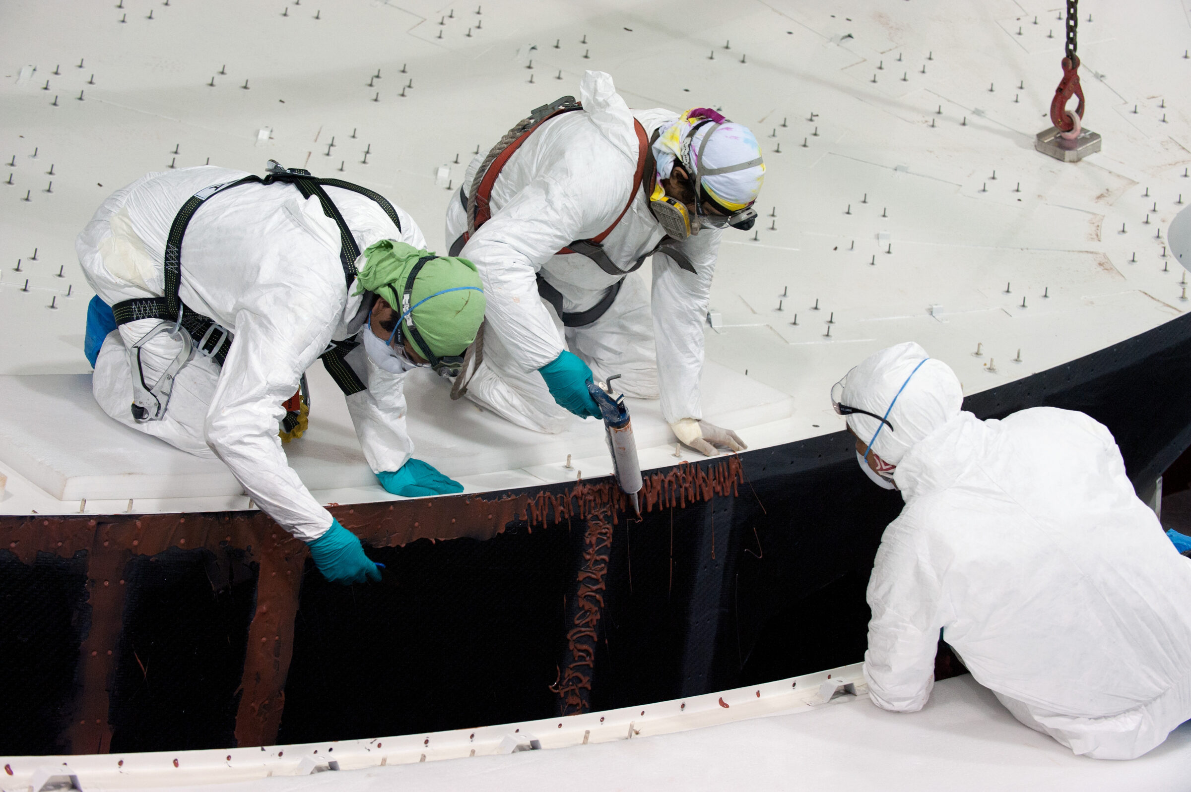 Technicians gluing parts of a plate