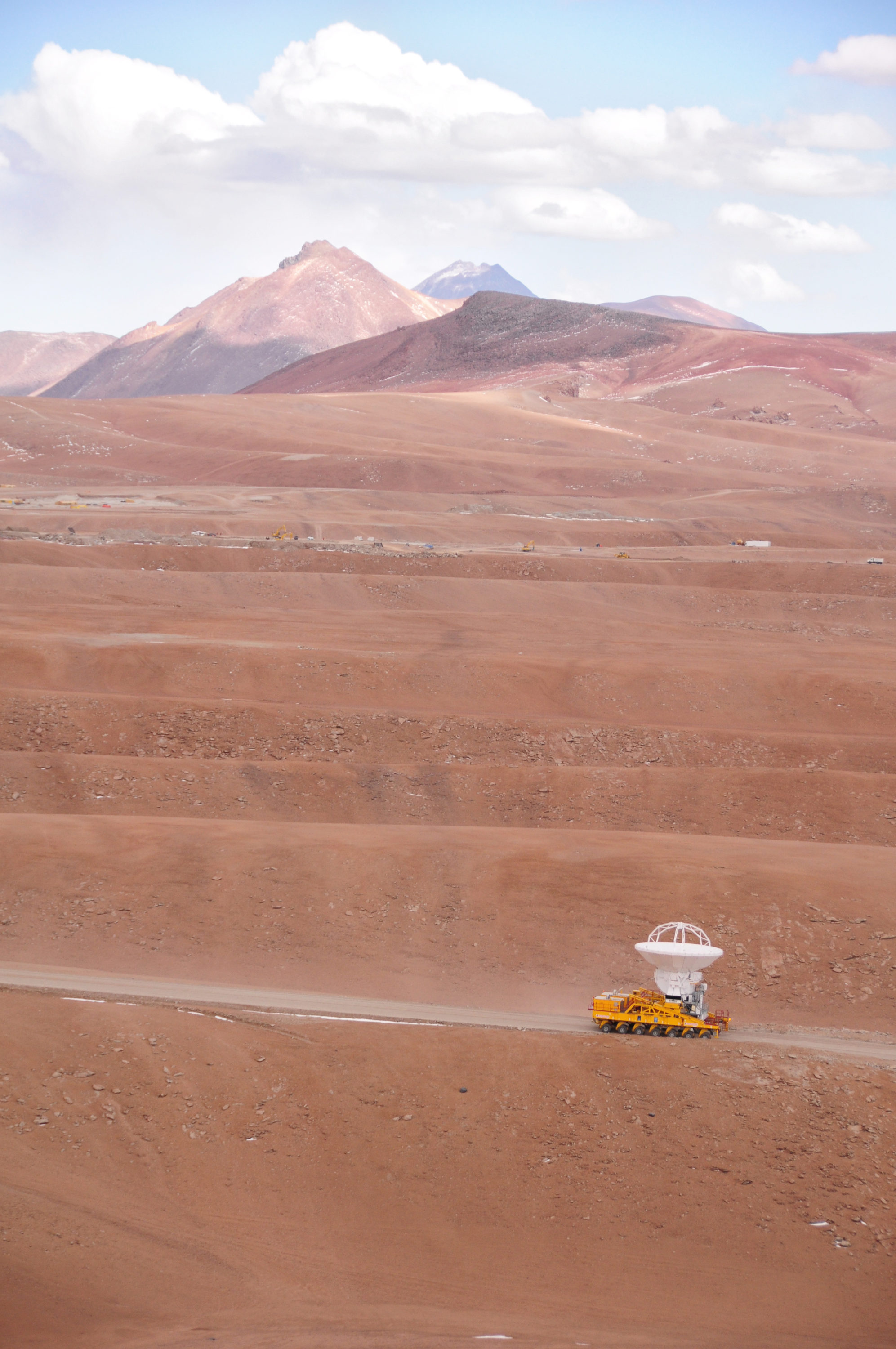 September 17, 2009: An ALMA antenna en route from the Operations Support Facility to the plateau of Chajnantor for the first time. The ALMA transporter vehicle carefully carries the state-of-the-art antenna, with a diameter of 12 meters and a weight of about 100 tons, on the 28 km journey to the Array Operations Site, which is at an altitude of 5000 m. The antenna is designed to withstand the harsh conditions at the high site, where the extremely dry and rarefied air is ideal for ALMA’s observations of the universe at millimeter- and submillimeter-wavelengths. © Ralph Bennett - ALMA (ESO/NAOJ/NRAO)
