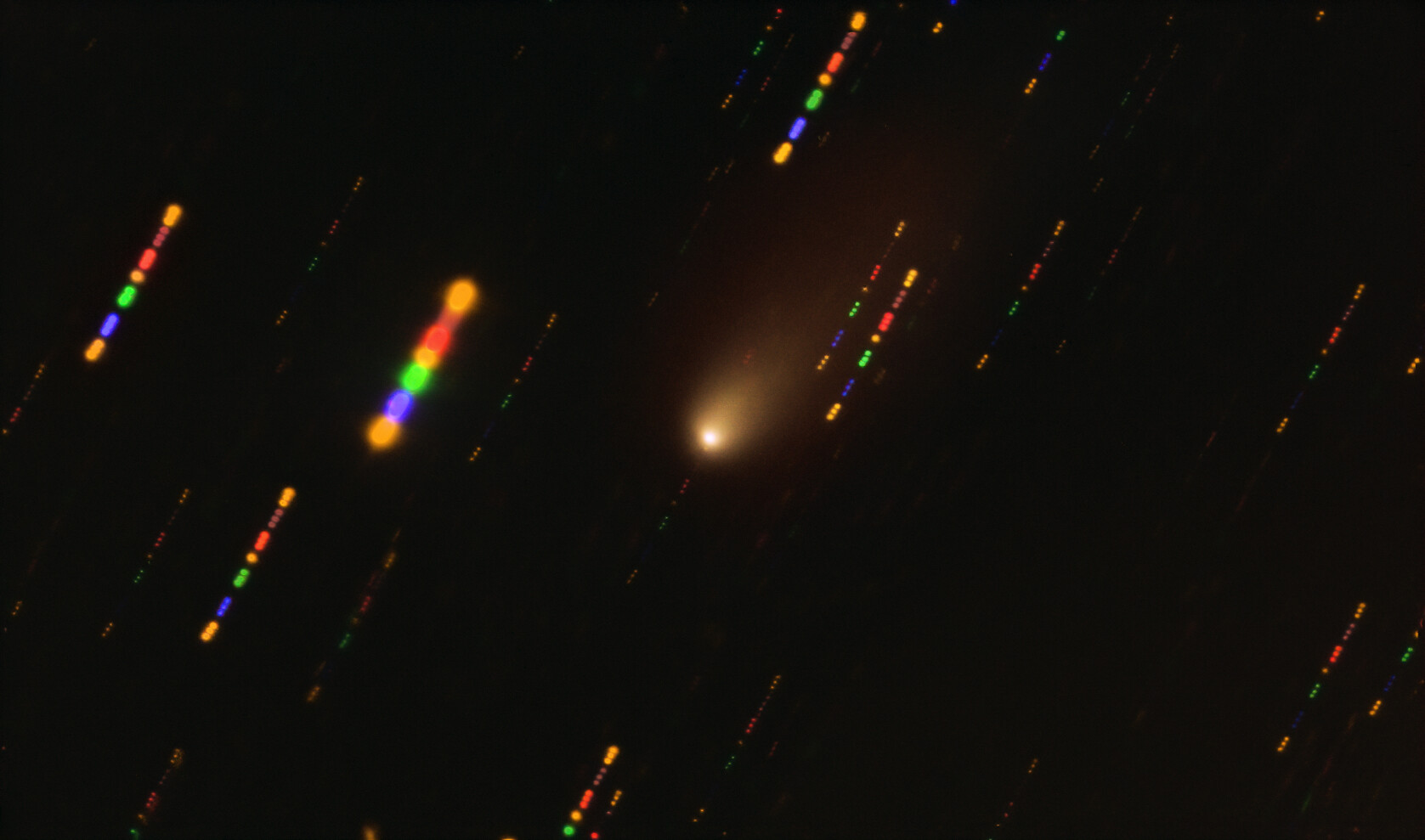 <p>This image was taken with the FORS2 instrument on ESO’s Very Large Telescope in late 2019, when comet 2I/Borisov passed near the Sun.  Since the comet was travelling at breakneck speed, around 175 000 kilometres per hour, the background stars appeared as streaks of light as the telescope followed the comet’s trajectory. The colours in these streaks give the image some disco flair and are the result of combining observations in different wavelength bands, highlighted by the various colours in this composite image. Credit: ESO/O. Hainaut</p>
