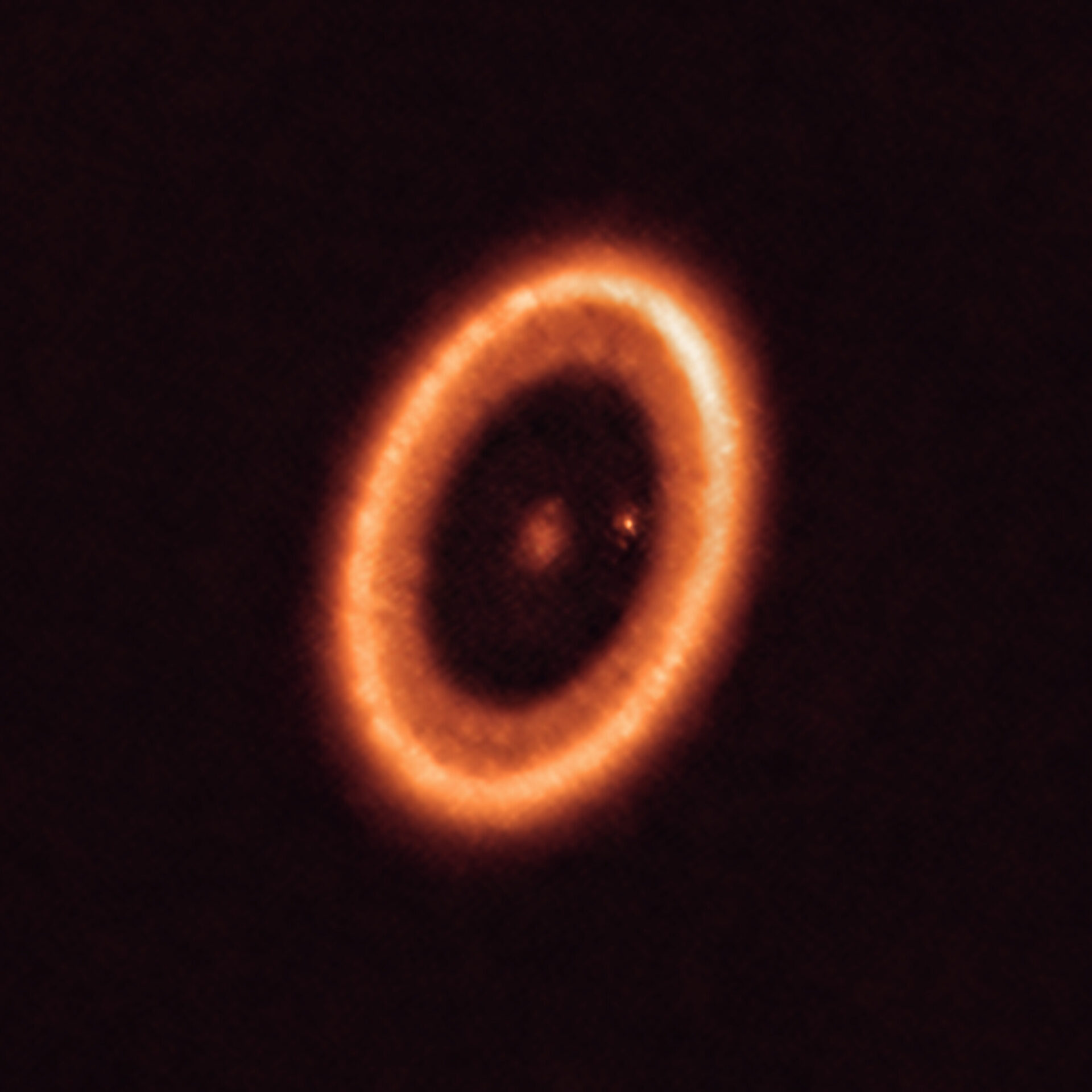 <p>Esta imagen, tomada con el Atacama Large Millimeter/submillimeter Array (ALMA), del que ESO es socio, muestra el sistema PDS 70, ubicado a casi 400 años luz de distancia y aún en proceso de formación. El sistema cuenta con una estrella en su centro y al menos dos planetas orbitando alrededor de ella, PDS 70b (no visible en la imagen) y PDS 70c, rodeado por un disco circumplanetario (el punto a la derecha de la estrella). Los planetas han horadado un hueco en el disco circunestelar (la estructura en forma de anillo que domina la imagen) a medida que engullían material del propio disco, creciendo en tamaño. Durante este proceso, PDS 70c adquirió su propio disco circumplanetario, que contribuye al crecimiento del planeta y en el cual se pueden formar lunas.</p>
<p>Crédito:<br />
ALMA (ESO/NAOJ/NRAO)/Benisty et al.</p>
