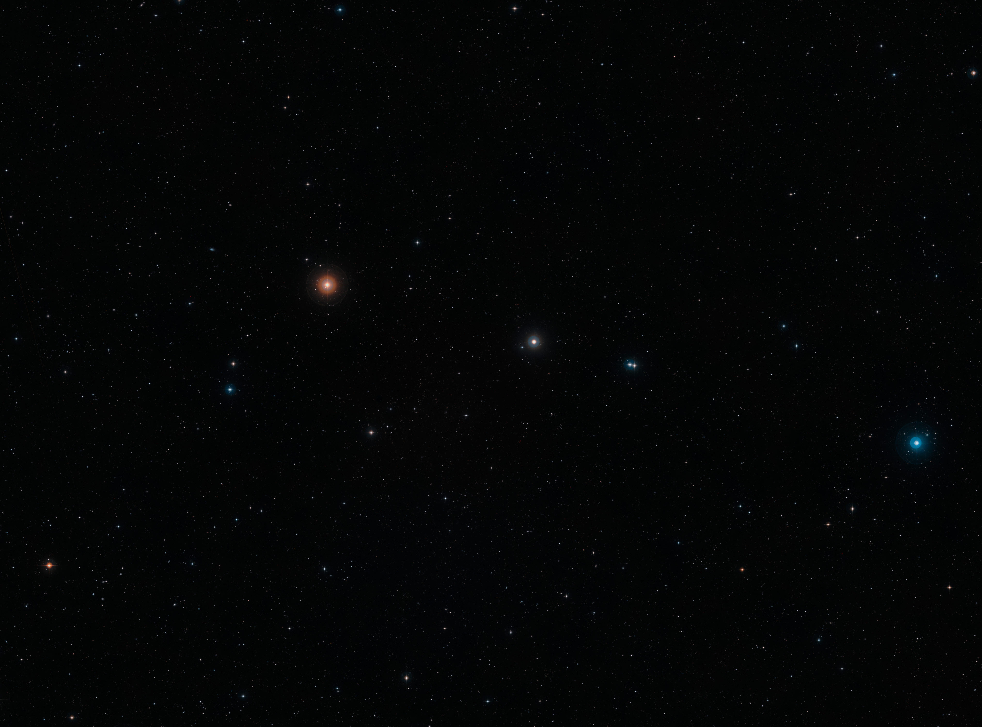 Esta imagen de campo amplio en luz visible de la región del cielo donde se encuentra la remota galaxia NGP-190387 se creó a partir de imágenes del Digital Sky Survey 2. La galaxia, situada tan lejos que su luz tardó más de 12 mil millones de años en llegar hasta nosotros, está cerca del centro de la imagen. Aunque no pueden verse en esta imagen, muchas galaxias más cercanas se pueden observar con una vista de campo amplio. Crédito: ESO/Digitized Sky Survey 2. Acknowledgement: Davide De Martin