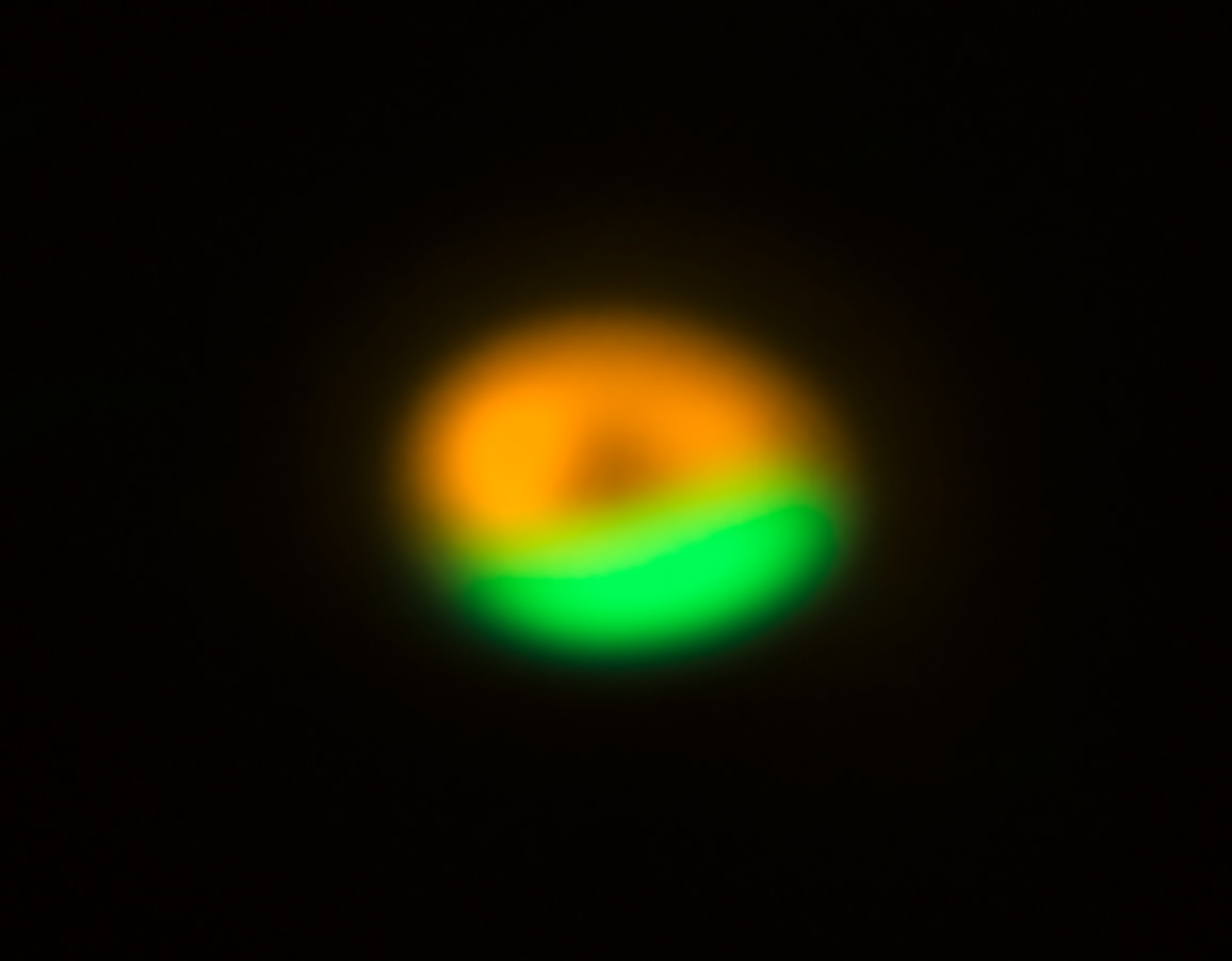 Esta imagen obtenida por ALMA (Atacama Large Millimeter/submillimeter Array) muestra la trampa de polvo en el disco que rodea al sistema Oph-IRS 48. La trampa de polvo proporciona un refugio para las pequeñas partículas del disco, permitiendo que se agrupen y crezcan hasta alcanzar tamaños que les permitan sobrevivir por sí solas. La región verde señala la zona en la que se encuentran las partículas de mayor tamaño (de milimétros) y la trampa de polvo descubierta por ALMA. El anillo anaranjado muestra observaciones de partículas de polvo mucho más finas (de micras) utilizando el instrumento VISIR, instalado en el telescopio VLT (Very Large Telescope) de ESO. Crédito: ALMA (ESO/NAOJ/NRAO)/Nienke van der Marel
