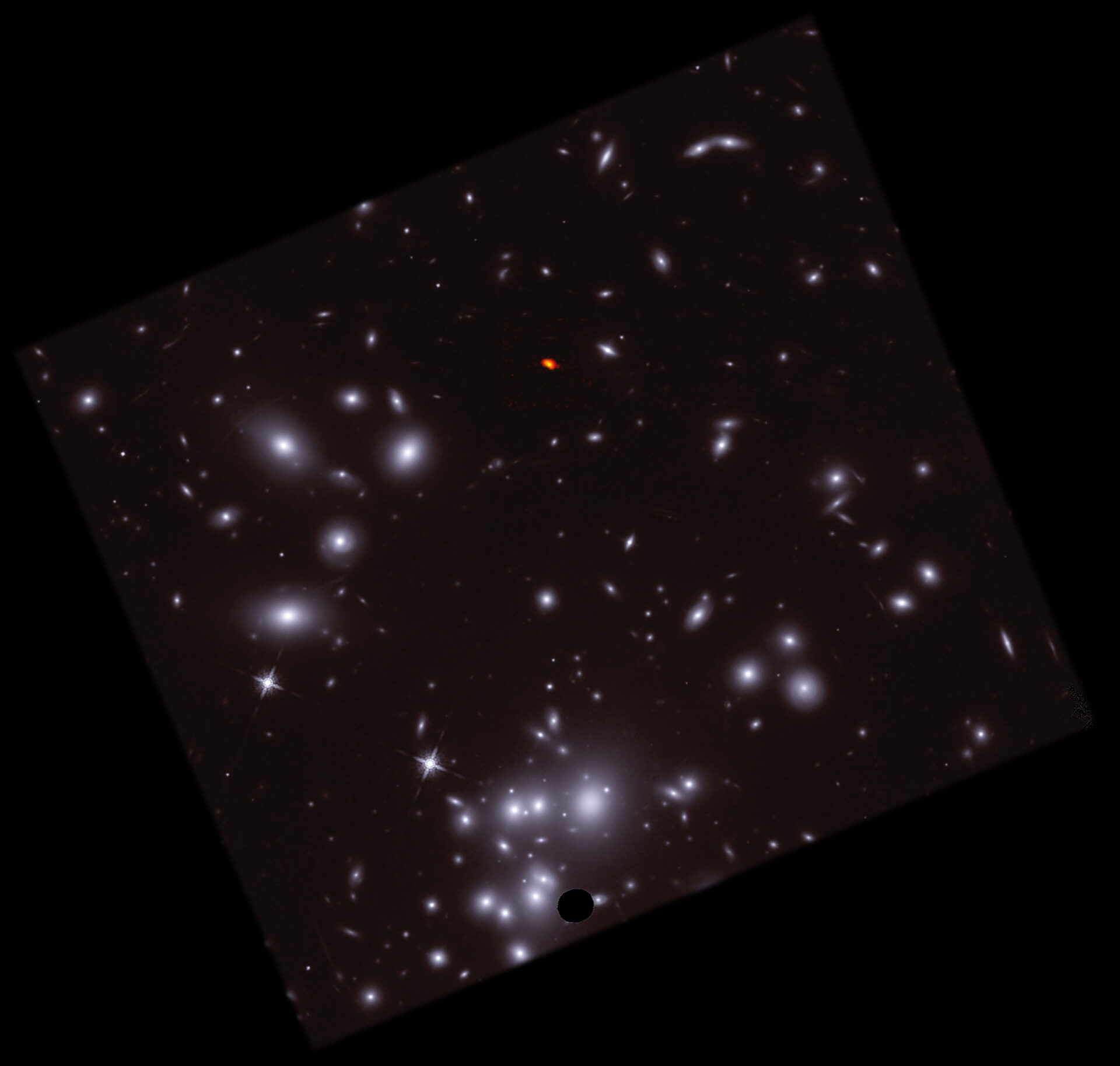 <p>This composite combines radio images of A1689-zD1, captured using the Atacama Large Millimeter/submillimeter Array (ALMA), shown in orange/red, with optical images from the Hubble Space Telescope (HST), shown in blue/white. In the context of its surroundings, it becomes clear how A1689-zD1 managed to “hide out” behind Abell 1689, and why gravitational lensing— the magnification of the young galaxy— are critical to studying its behaviors and processes. Credit: ALMA (ESO/NAOJ/NRAO)/H. Akins (Grinnell College), HST, B. Saxton (NRAO/AUI/NSF)</p>
