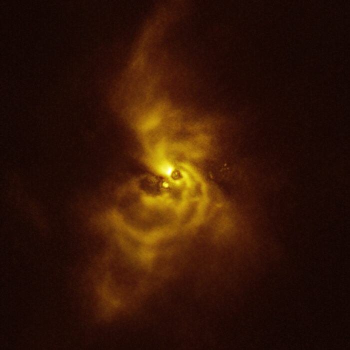 This image of the young star V960 Mon and its surrounding material was taken with the Spectro-Polarimetric High-contrast Exoplanet REsearch (SPHERE) instrument on ESO’s VLT. The material orbiting the young star is assembling together in a series of intricate spiral arms that  extend to distances greater than the entire Solar System. Credit: ESO/Weber et al.